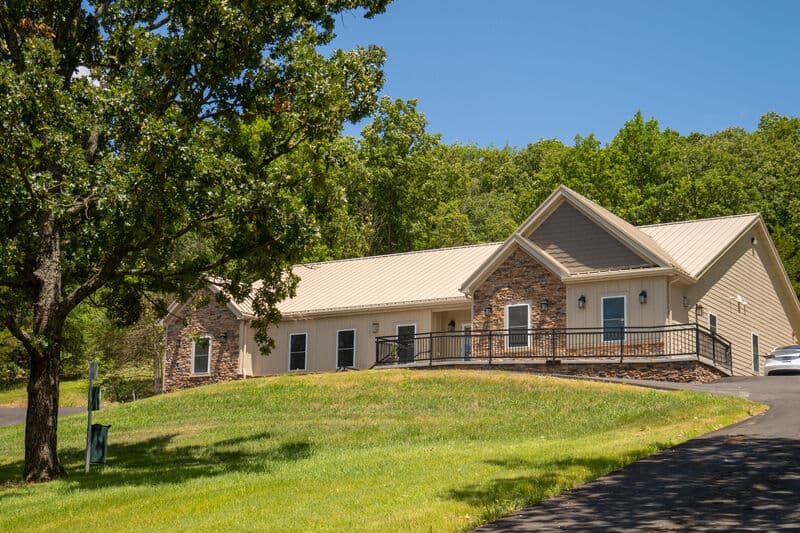 Exterior  of single story condo building with large lawn and driveway