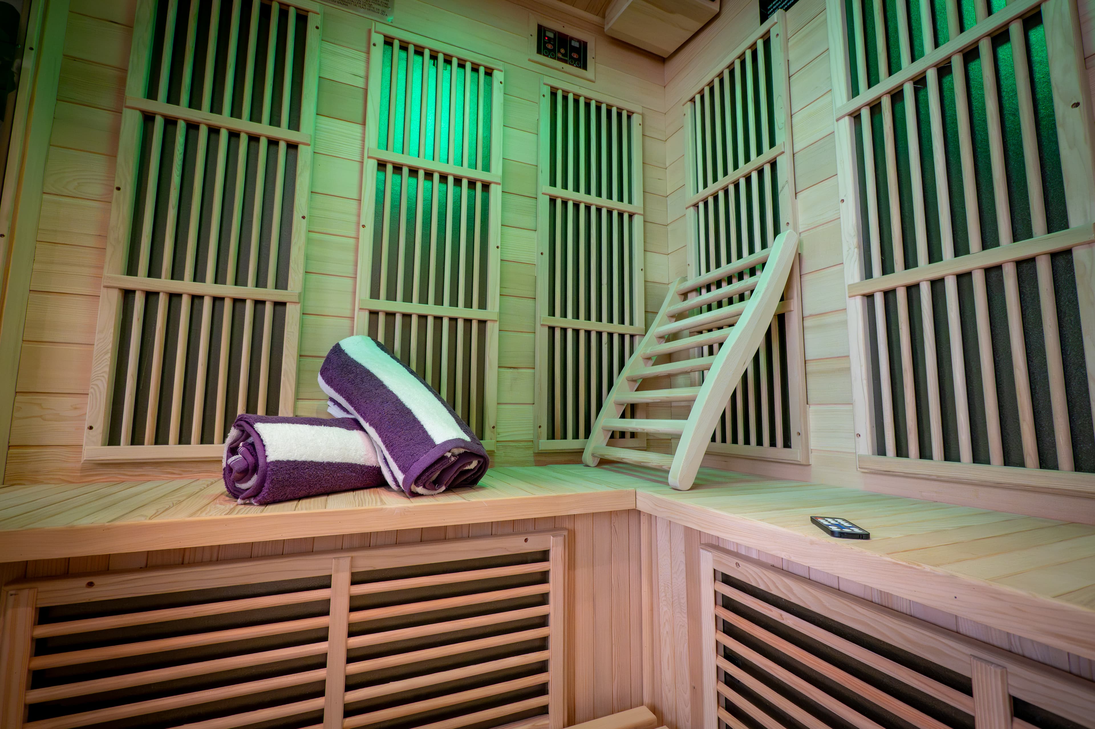 inside of infered sauna seat with two towels rolled up on bench.