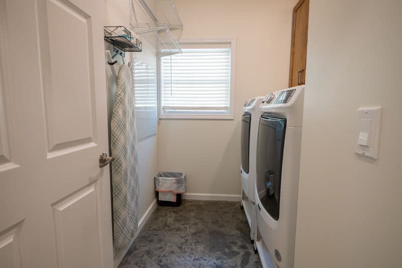 laundry room with front load machines and small window on far wall