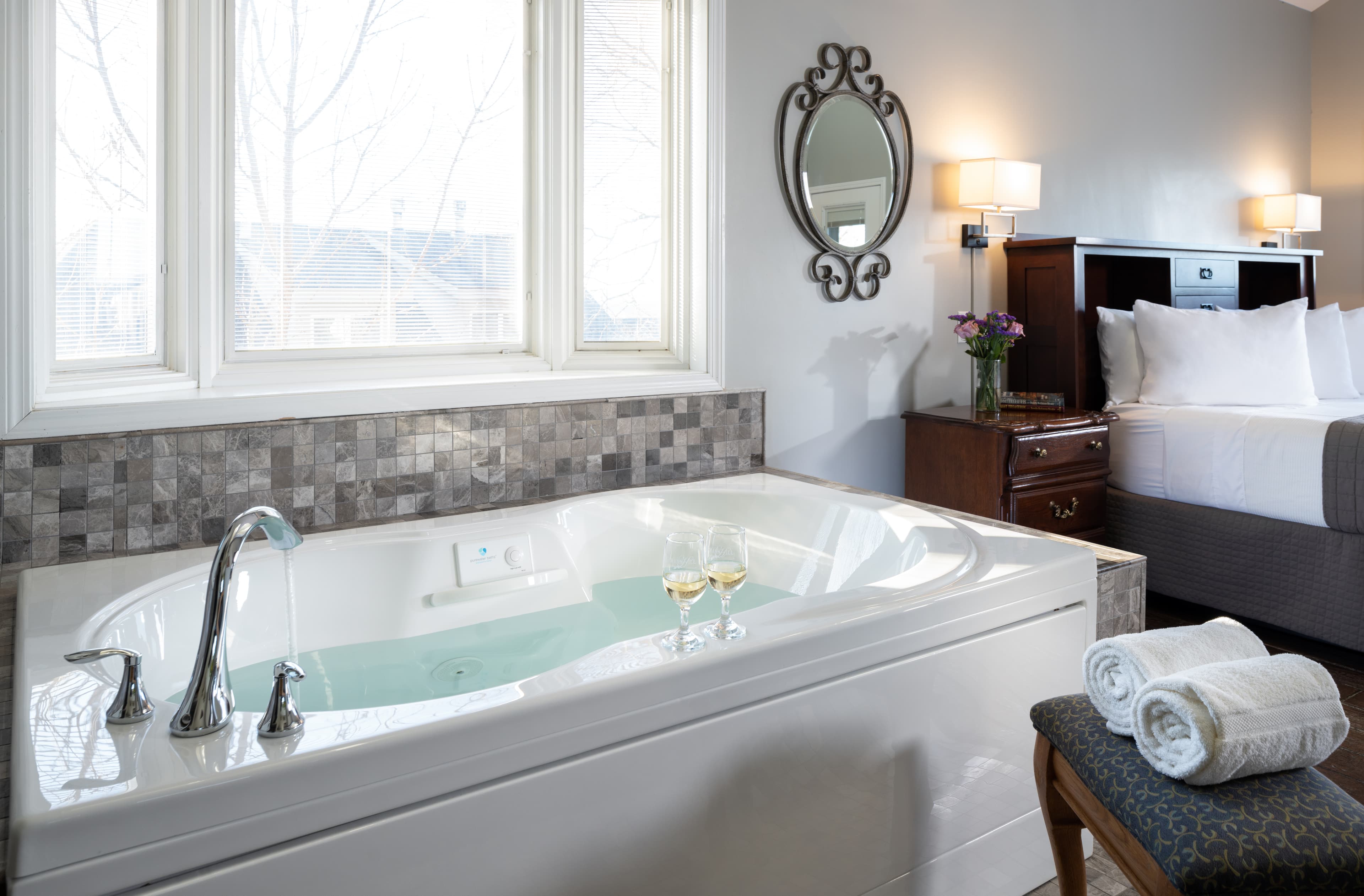 Jetted tub and bed in background