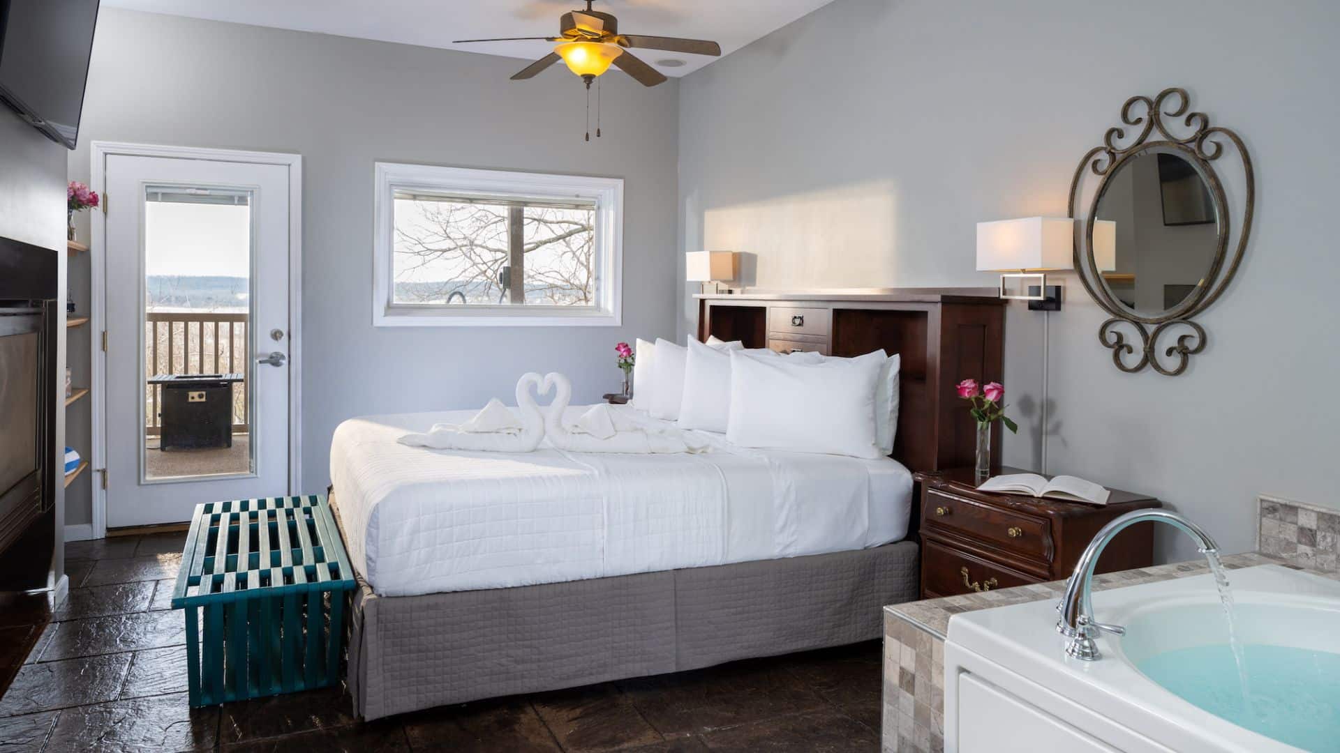A cozy hotel room featuring a king-sized bed, ensuite jacuzzi, and balcony access.