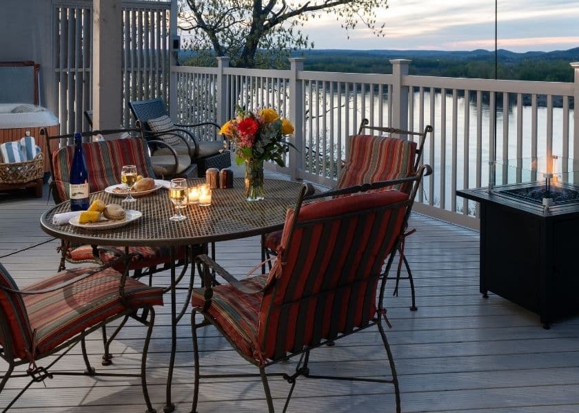 A cozy dining setup on a deck overlooking a serene river at sunset. A cozy dining setup on a deck overlooking a serene river at sunset.