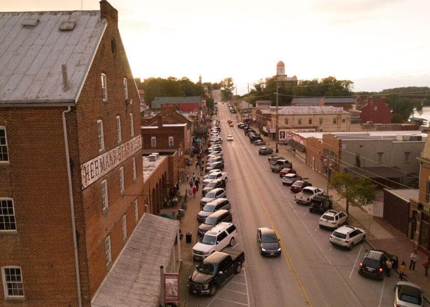 Aerial view of a street lined with parked cars and buildings during sunset. Aerial view of a street lined with parked cars and buildings during sunset.