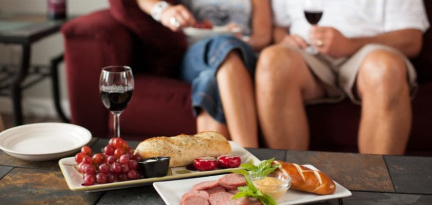 Couple enjoying a charcuterie board with wine, bread, and grapes at Hermann Hill.