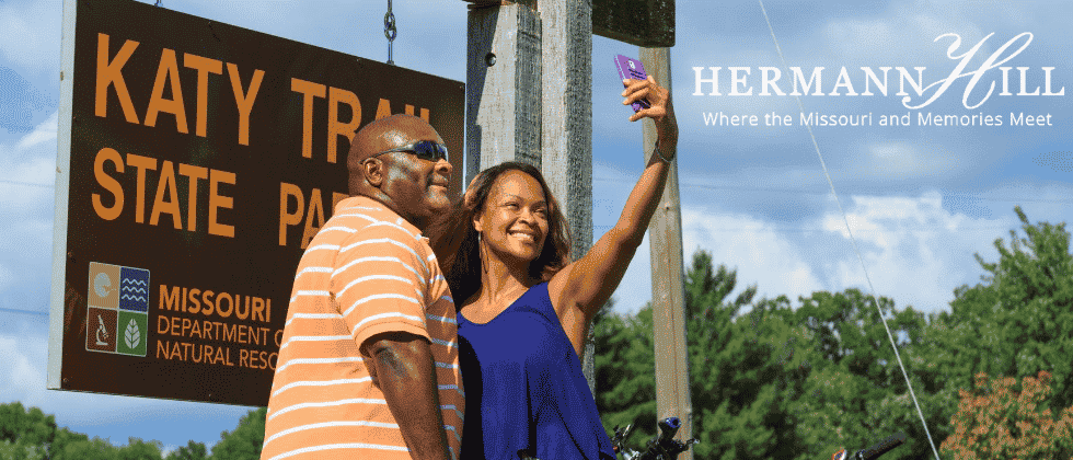 Couple taking a selfie in front of the Katy Trail sign