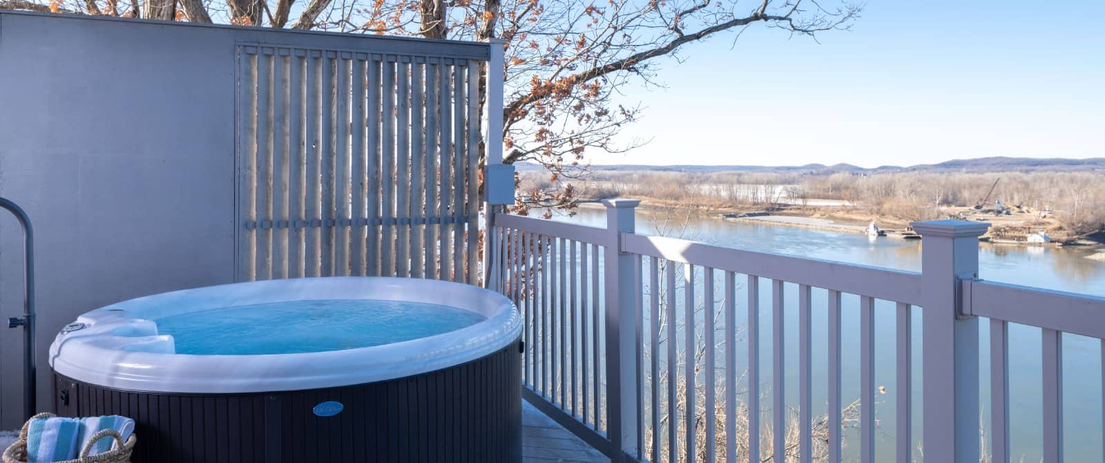 Deck with small jetted tub and view of river in the background
