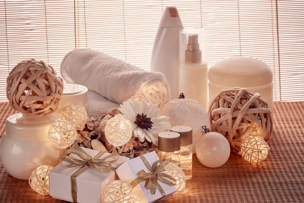 Spa still life with cosmetic creams, towel, and gift boxes