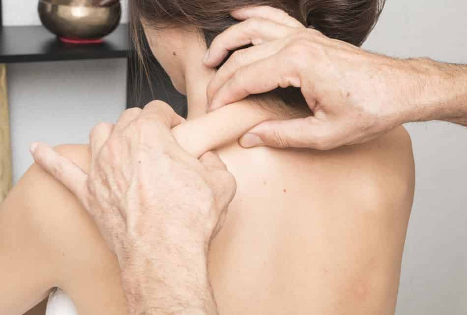 Man pinching pressure points on a woman's back